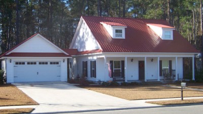 Cinnamon rib roof over a white, paneled house