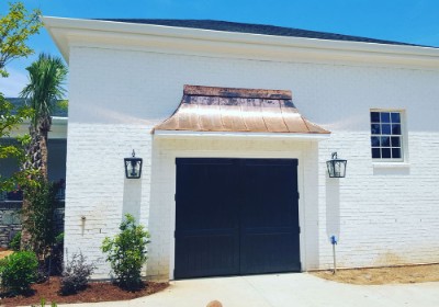 Copper metal roof awning over a black door